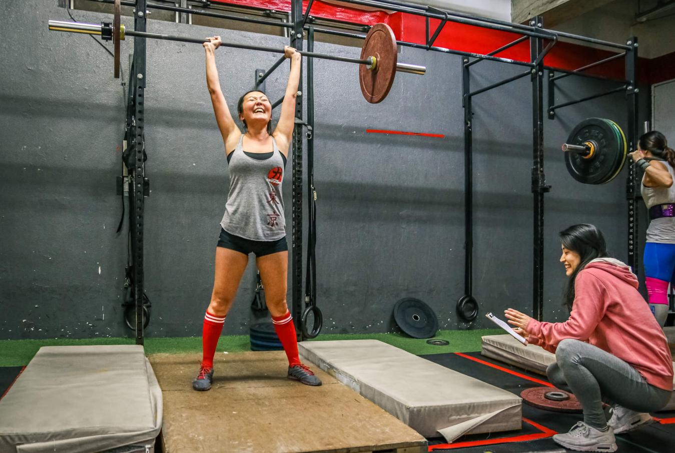 Member celebrates with barbell overhead during CrossFit Open